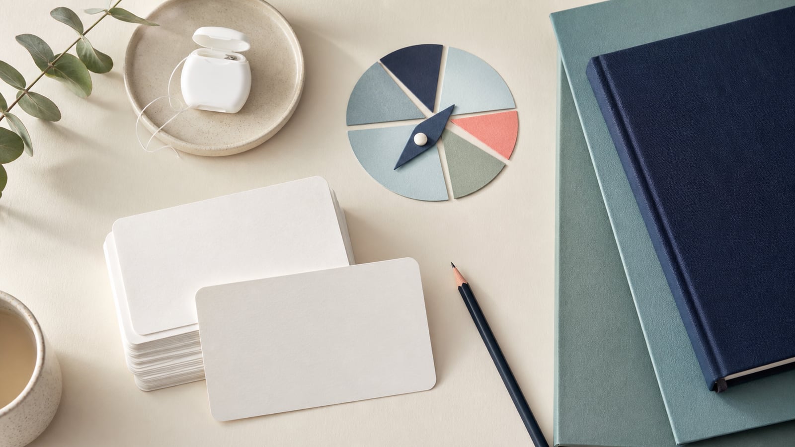 A quiet review desk with blank cards, a pencil, floss, and calm compass-inspired paper shapes.